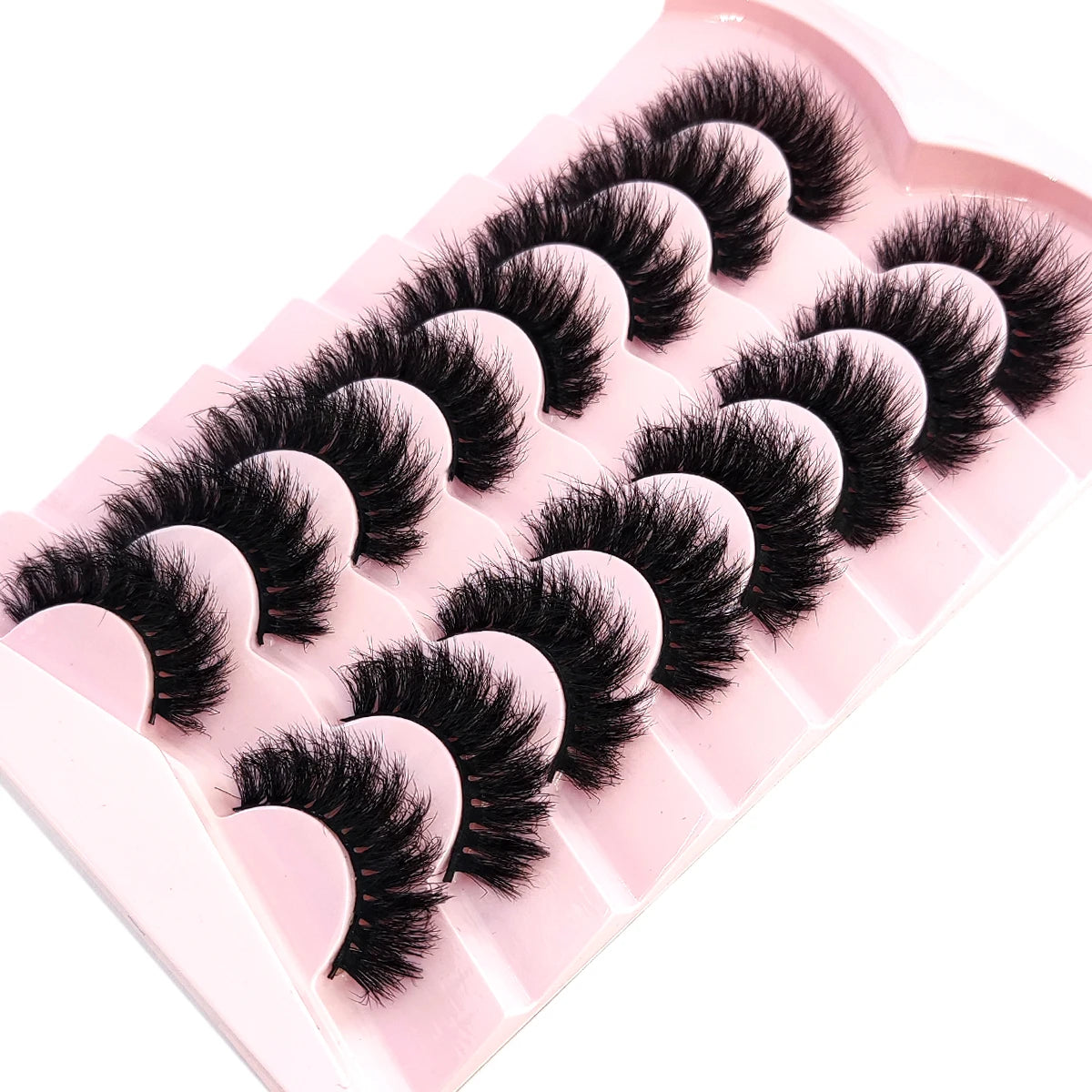 A pink plastic tray holding several pairs of black mink striped false eyelash extensions.
