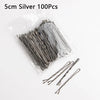A clear plastic bag containing 100 silver 5cm metal U-shaped hair pins for styling.