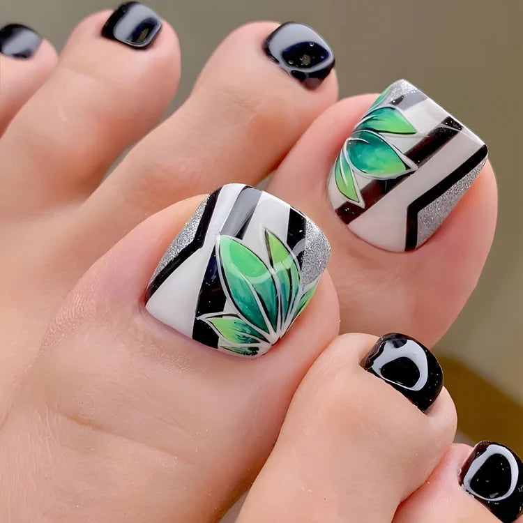 Nahaufnahme einer Hand, die wiederverwendbare französische Fake-Nagel mit schwarz-weißen geometrischen Mustern und grünem Des
