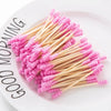 Une pile de cotons-tiges roses sur une assiette blanche avec les mots 'GOOD MORNING' visibles.
