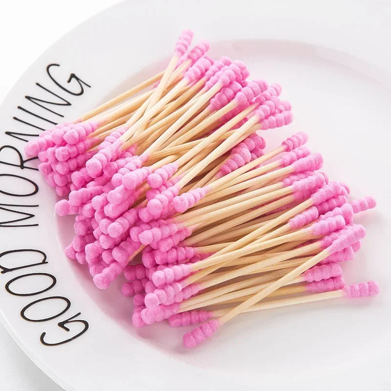 Une pile de cotons-tiges roses sur une assiette blanche avec les mots 'GOOD MORNING' visibles.