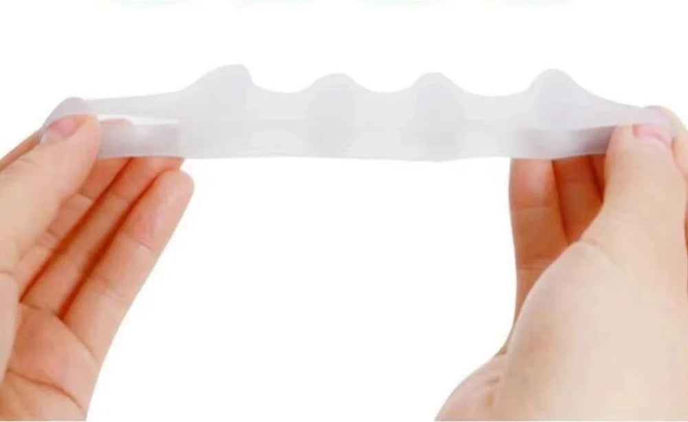 A hand holds a white silicone toe separator designed for foot and bunion relief.