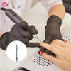 Hands wearing black gloves are using a diamond nail drill bit on a finger for professional manicure work.