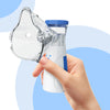 A hand holds a clear facial steamer and humidifier device against a light blue background.