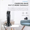 A black electric hair clipper grooming kit charging base with a cord placed on a white table.