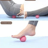 A person is using a pink deep tissue massage ball on their foot for relaxation and muscle massage.