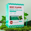 Boîte de 750 picks de dentifrice professionnel en menthe sur fond de mousse verte