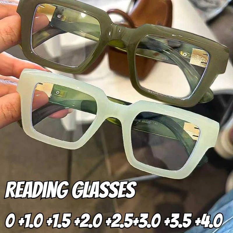 Une main tient une paire de lunettes à monture carrée rétro vert clair avec divers numéros de prescription écrits en dessous.