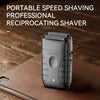 A portable reciprocating shaver in black rests on a brown leather surface.