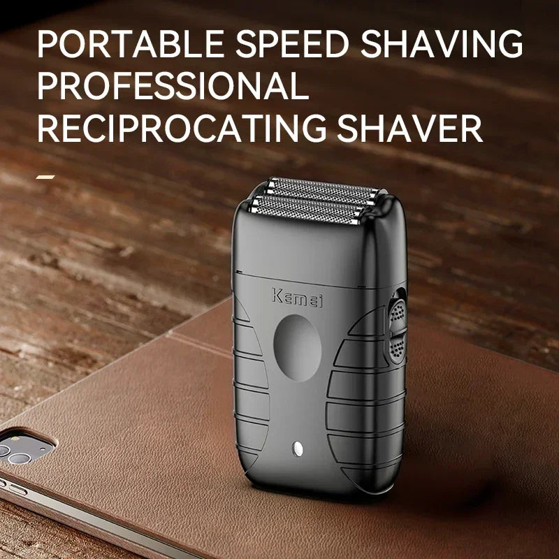 A portable reciprocating shaver in black rests on a brown leather surface.