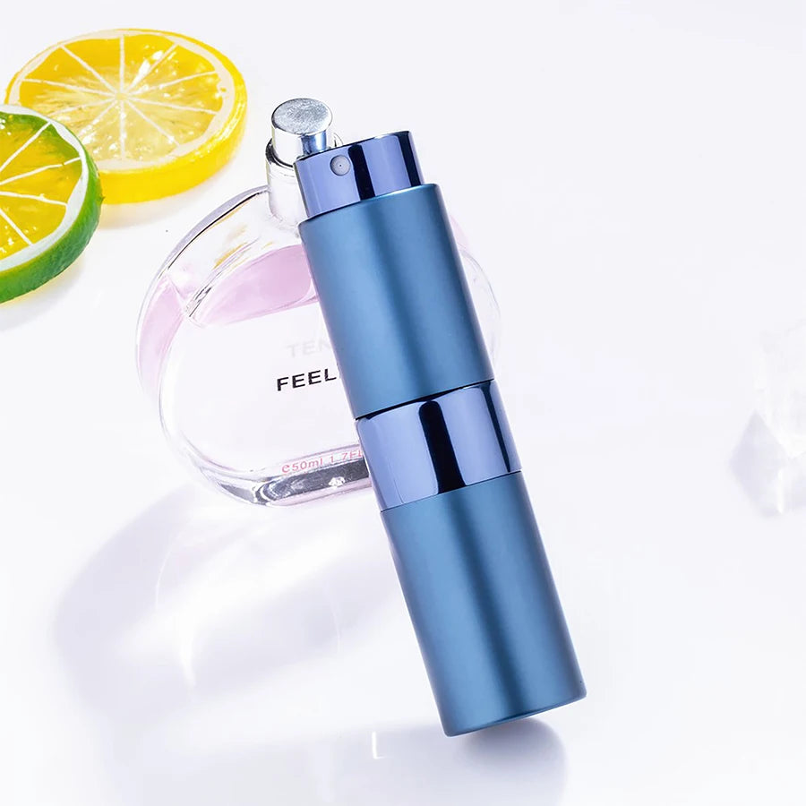 Un flacon d'atomiseur de parfum bleu à côté d'une bouteille en verre et d'une tranche de citron.