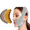A woman is shown using a grey lymphatic sculpting bandage and massage brush set on her face and ear.