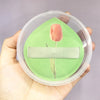A pink tulip design on a light green silicone makeup puff set inside a clear storage box.