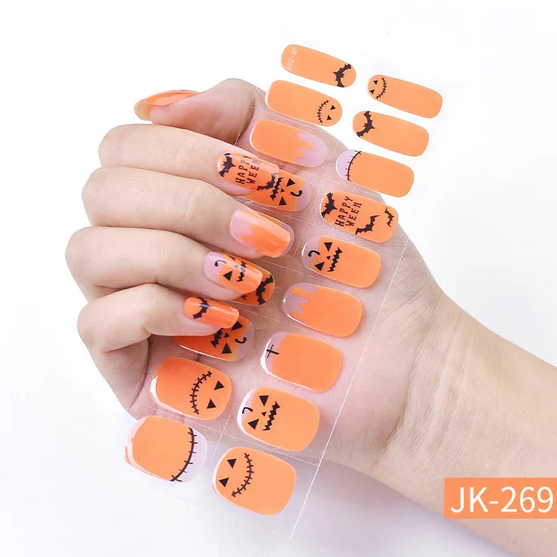 Hand displaying orange Halloween themed UV gel nail stickers for full coverage decals