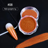 A small glass jar of orange-colored nail glitter powder next to a single orange chrome nail and a swatch of the same color.