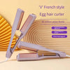 A purple V French style egg hair curler is shown with a cord, resting on a light background.