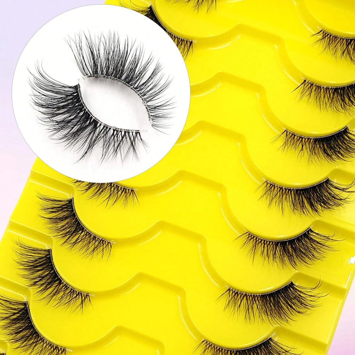 A yellow tray of wispy black cat eye false eyelashes is shown, with a close-up of the lashes.