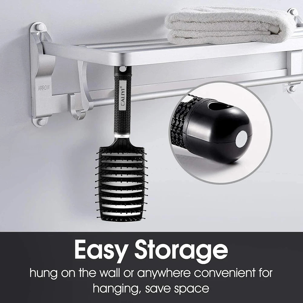 A black curved vented hair brush is hanging on a silver metal rack mounted on a wall.