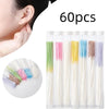 Una colección de 60 palitos para limpiar piercings desechables en varios colores y longitudes.