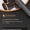 A close-up of a professional hair dryer with a matte black body and rose gold accents, showing its nozzle and power switch fe