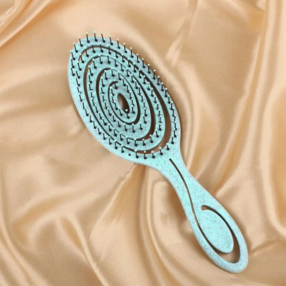 Peigne en silicone bleu clair avec de nombreuses petites dents, sur un fond de tissu pêche fluide.
