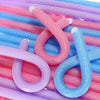 A collection of colorful soft foam heatless hair rollers in pink, blue, and purple.