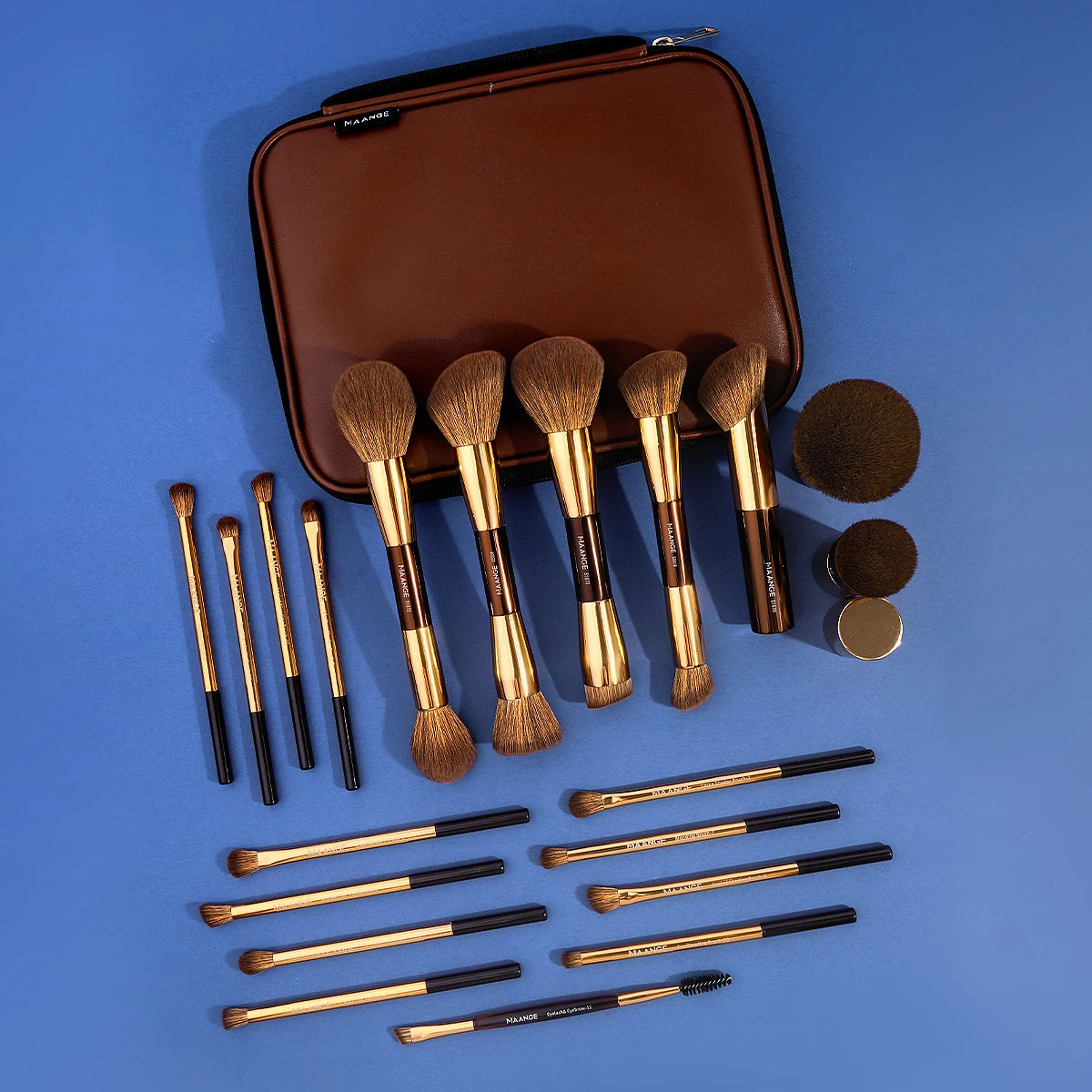 A brown makeup brush set with various sizes and a travel case is displayed on a blue surface.