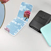 A collection of portable LED magnifying makeup mirrors in various colors, including black, mint green, and pink, displayed on