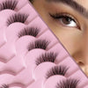 Primer plano de una bandeja de pestañas rosa con extensiones naturales y finas en un ojo.