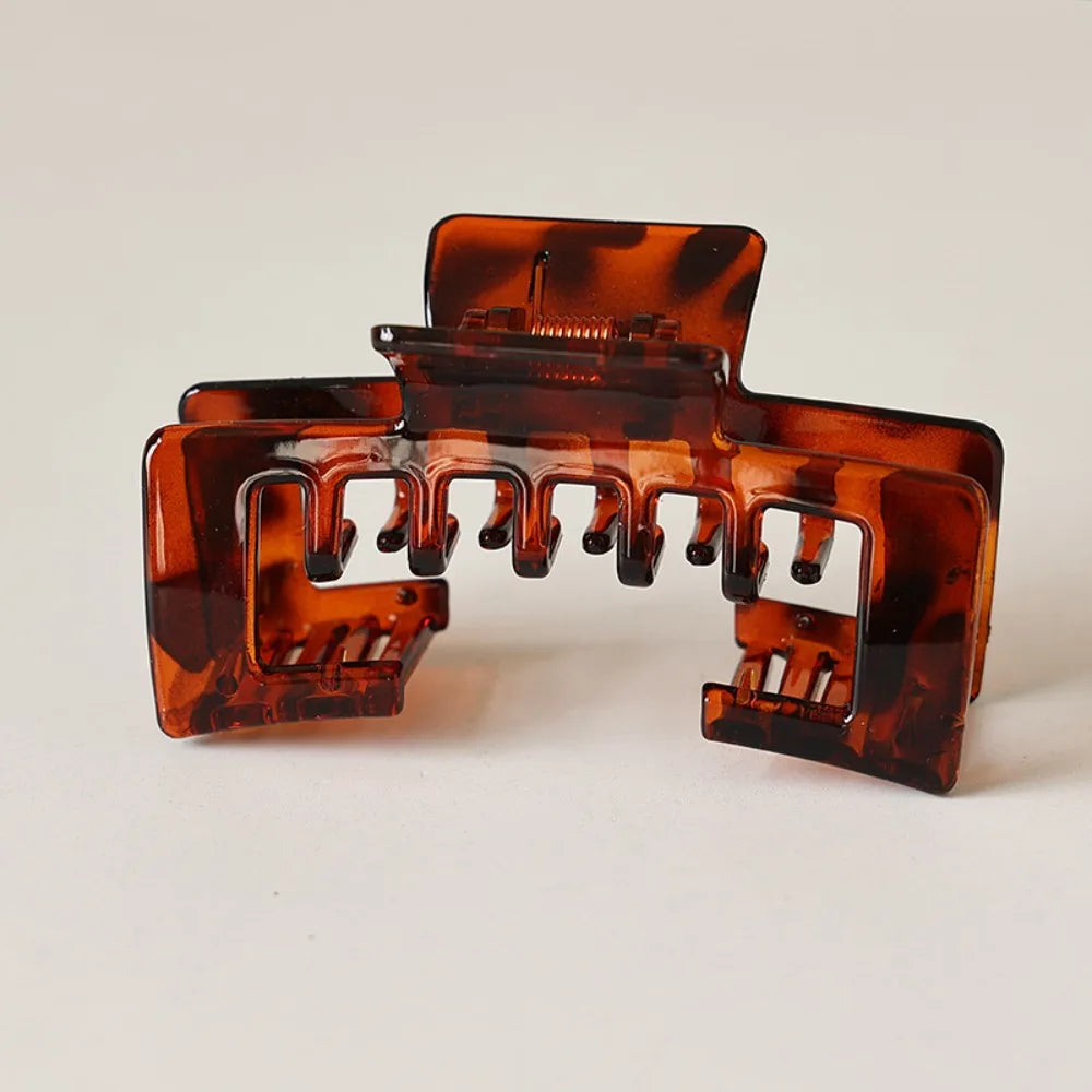 A close-up of a tortoiseshell patterned non-slip hat claw clip with a matte finish.