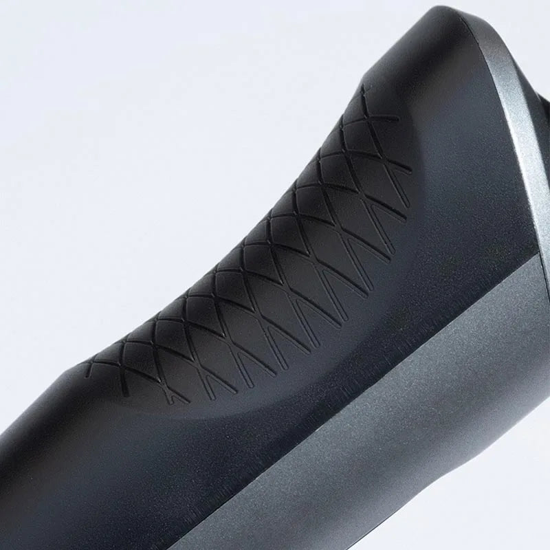 Close-up view of a black electric shaver and trimmer with textured grip.