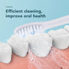 A white electric toothbrush is shown cleaning a pink surface, with toothpaste foam visible and a toothbrush nearby.