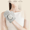 A person is using a silver electric hand massager device on their forearm for massage.