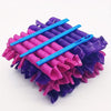 A set of purple and pink heatless hair curlers with blue handles arranged in a fan shape.