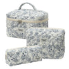 A quilted cotton makeup bag with a zipper closure featuring a blue floral pattern on a white background.