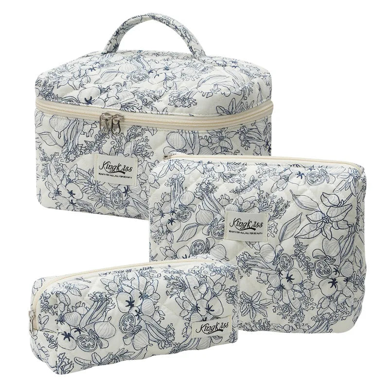 A quilted cotton makeup bag with a zipper closure featuring a blue floral pattern on a white background.