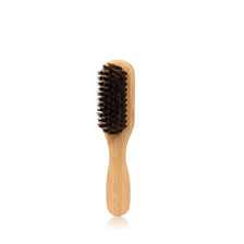 A wooden boar bristle hair brush with a natural wood handle.