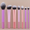 A set of seven professional makeup brushes in various shades of pink and purple