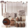 A collection of professional makeup brushes and sponges in various shades of beige and brown.