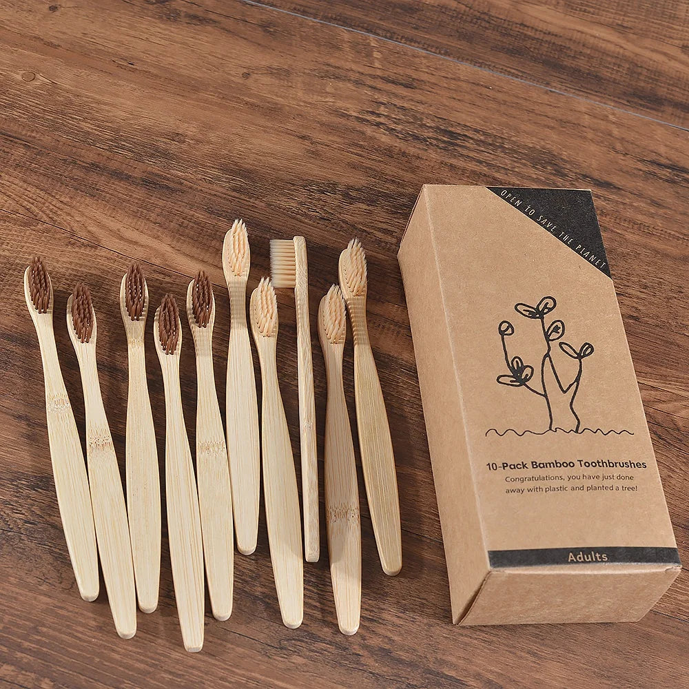 Une boîte contenant dix brosses à dents en bambou posées sur une surface en bois.