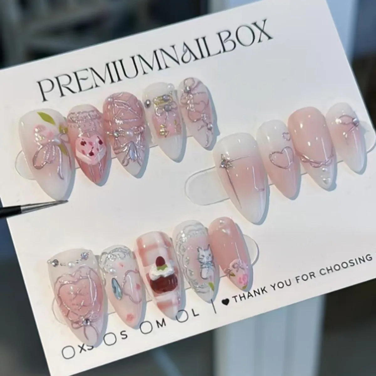 A display of premium nailbox featuring 24 pink heart pearl press-on fake nails.