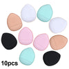 Dix mini éponges de fond de teint dans diverses teintes, y compris blanc, rose, pêche et noir.