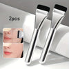 Two silver oval foundation brushes shown next to close-ups of their application on the face.