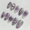 A set of 24 press-on fake nails featuring a lilac gradient and silver heart designs.