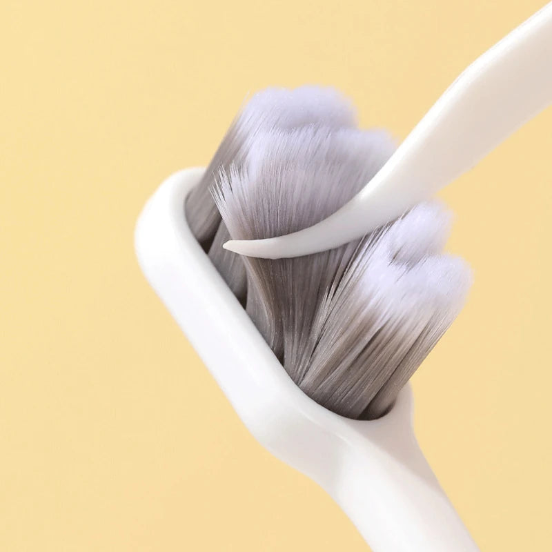 A close-up of a white toothbrush holder with soft gray bristles visible.