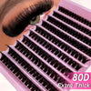 A close-up of a pink eyelash cluster kit showing black false lashes applied to an eye.