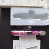 A pink eye massager wand is shown next to its packaging and instructions.