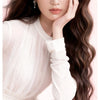 A woman with long dark hair is shown applying a professional beach waver curling iron for quick and beautiful style.