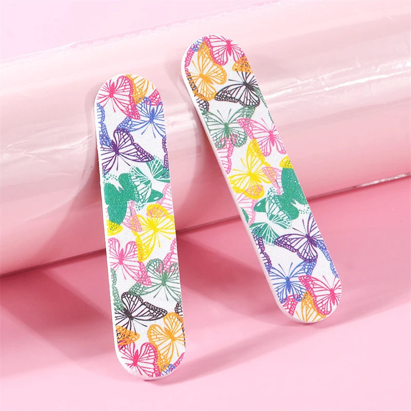 A set of double-sided nail files and buffing blocks featuring a colorful butterfly pattern on pink packaging.