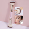 A long, double-ended makeup brush with a gold handle and fluffy bristles is shown next to close-up views of its application.